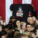 An audience member holds up a t-shirt that reads RUN DC and depicts President Obama as a member of the rap group RUN DMC during the President's stop at the Al Glick Fieldhouse on Friday morning.  Melanie Maxwell I AnnArbor.com